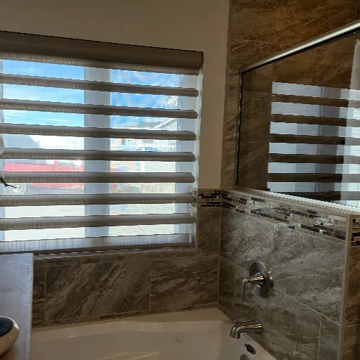 Open Stria blinds over shower and tub tile 